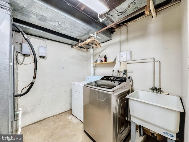 clothes washing area featuring sink and washing machine and clothes dryer