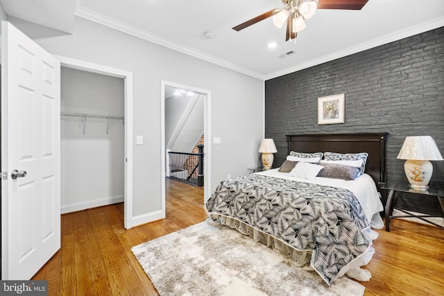 bedroom featuring wood-type flooring, a closet, ceiling fan, and ornamental molding