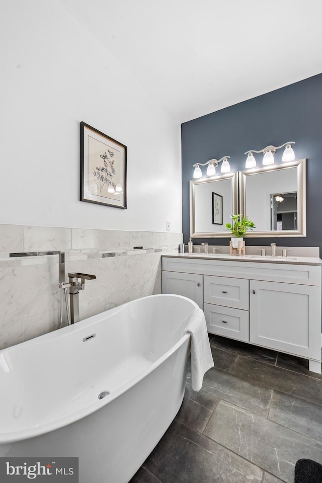 bathroom with vanity, a bathtub, and tile walls