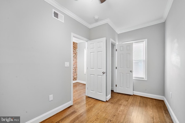 unfurnished bedroom featuring light wood-type flooring and crown molding