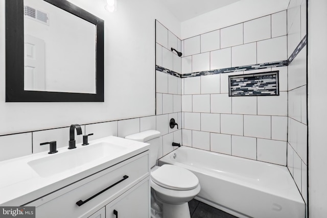 full bathroom with tiled shower / bath combo, toilet, decorative backsplash, and vanity