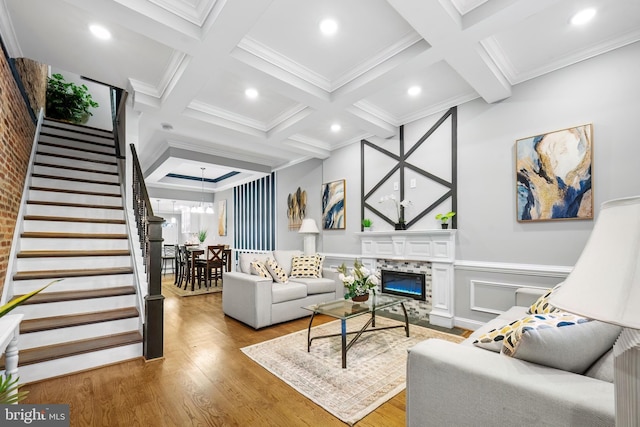 living room with beamed ceiling, ornamental molding, hardwood / wood-style flooring, and coffered ceiling