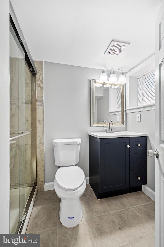 bathroom with tile patterned flooring, vanity, toilet, and an enclosed shower