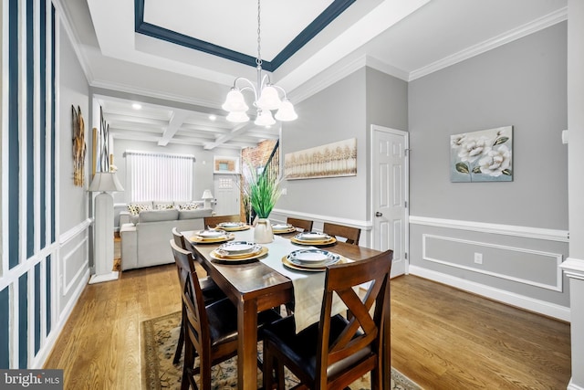 dining room featuring coffered ceiling, crown molding, an inviting chandelier, beamed ceiling, and hardwood / wood-style floors