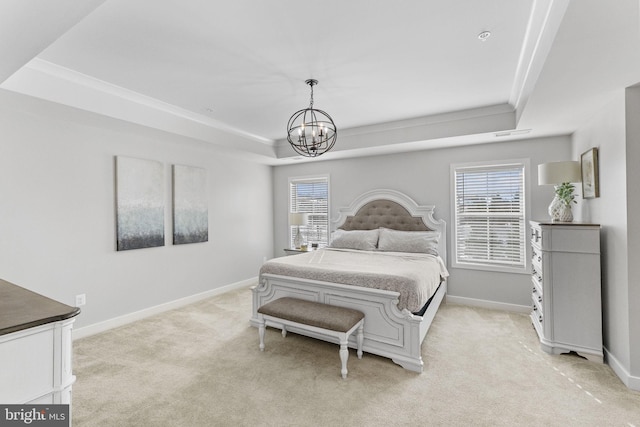 carpeted bedroom with a raised ceiling, multiple windows, and a notable chandelier