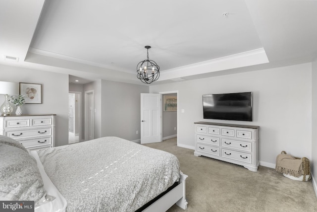 bedroom featuring a chandelier, a tray ceiling, and light carpet