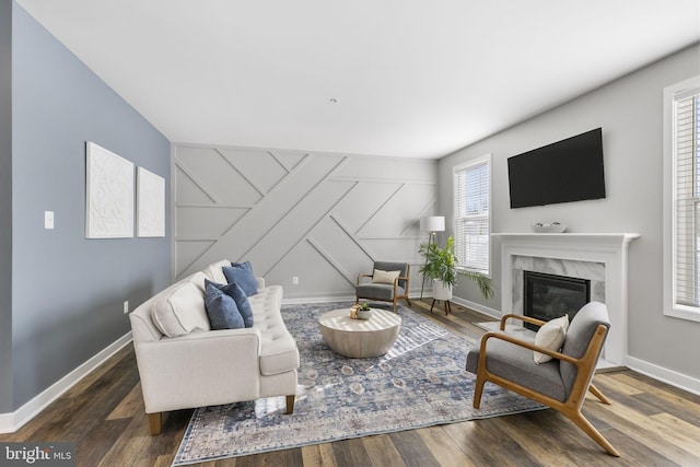 living room with a high end fireplace and dark hardwood / wood-style floors