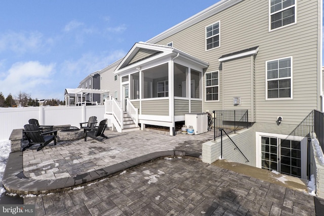 back of house with a fire pit, a sunroom, and a patio