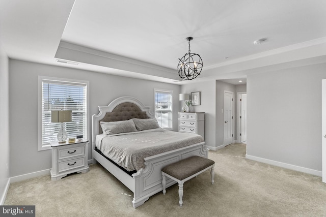 bedroom with light colored carpet, a raised ceiling, a notable chandelier, and multiple windows