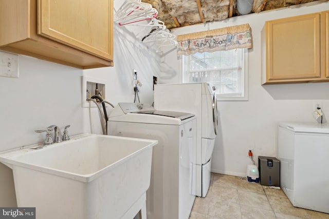 washroom featuring washing machine and clothes dryer, sink, light tile patterned floors, and cabinets