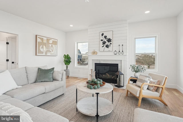 living room featuring light wood-type flooring and a large fireplace