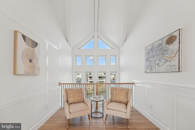 living area with light hardwood / wood-style floors and high vaulted ceiling