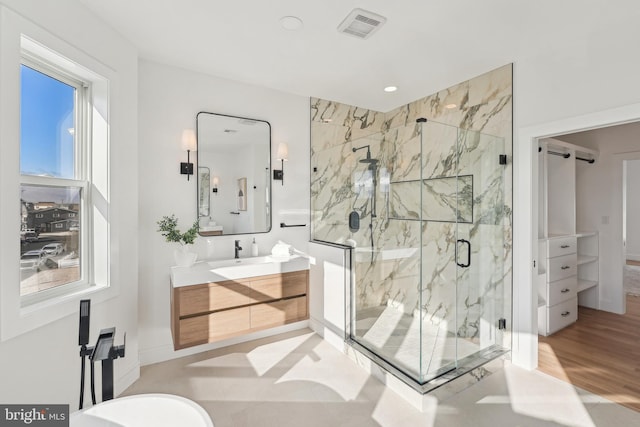 bathroom featuring hardwood / wood-style floors, vanity, a healthy amount of sunlight, and an enclosed shower