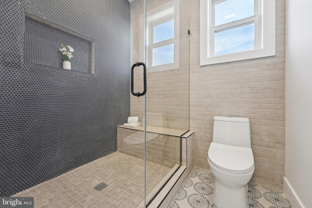 bathroom with tile patterned flooring, a shower with shower door, and toilet