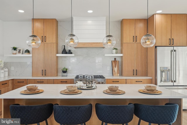 kitchen with light stone counters, stove, high quality fridge, decorative backsplash, and a breakfast bar