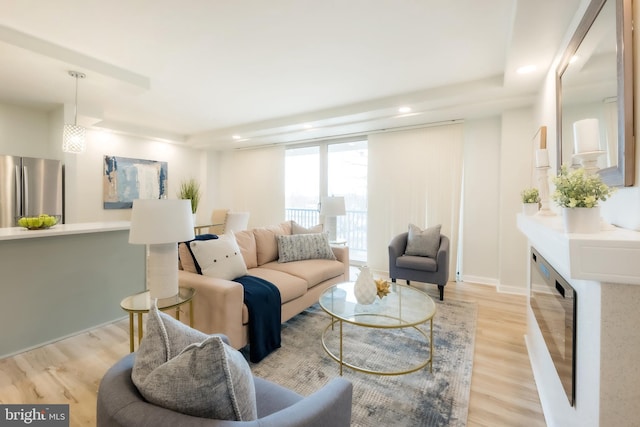 living room with a wall of windows, light hardwood / wood-style flooring, and beverage cooler