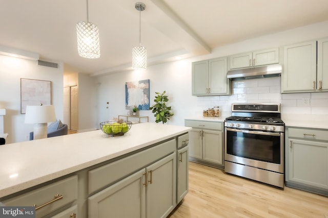 kitchen featuring backsplash, pendant lighting, beam ceiling, light hardwood / wood-style flooring, and stainless steel stove