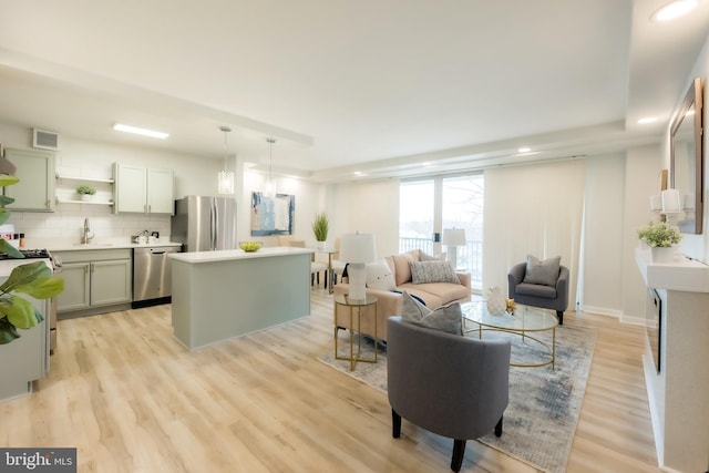 living room with light hardwood / wood-style floors and sink