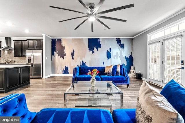 living room featuring ceiling fan, ornamental molding, and light hardwood / wood-style flooring