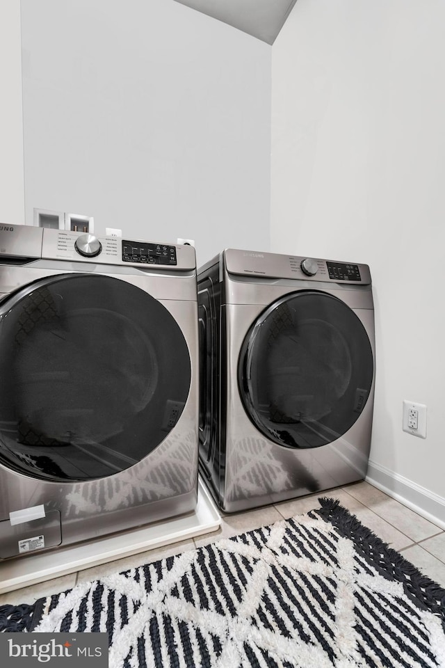 laundry room with light tile patterned floors and washer and clothes dryer