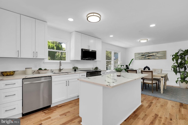 kitchen with white cabinetry, dishwasher, a center island, sink, and light hardwood / wood-style floors