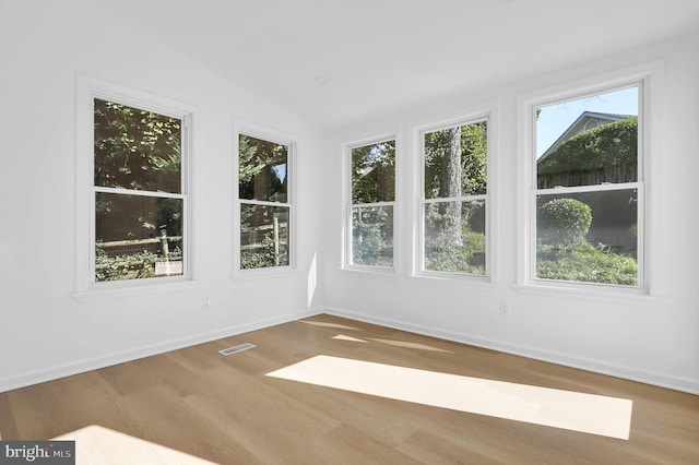 unfurnished sunroom featuring vaulted ceiling