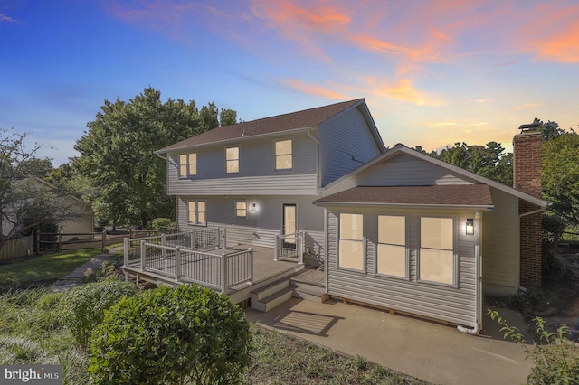 back house at dusk with a deck