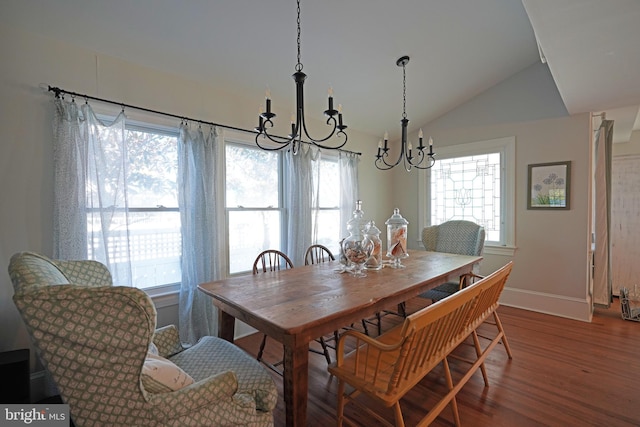 dining area featuring a notable chandelier, vaulted ceiling, and hardwood / wood-style floors