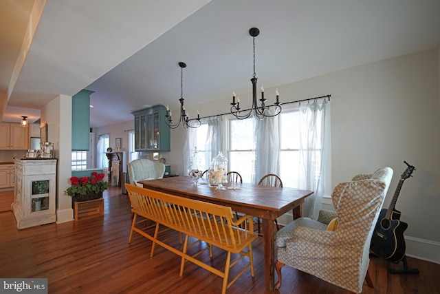 dining area with a notable chandelier, a wealth of natural light, and dark hardwood / wood-style floors