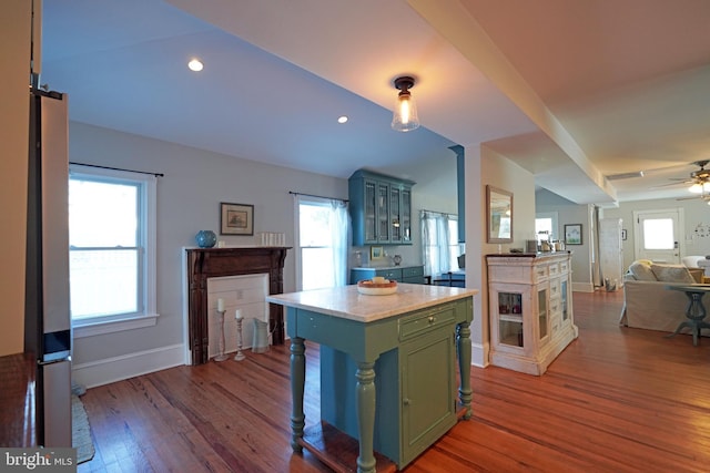 kitchen featuring hardwood / wood-style flooring, vaulted ceiling, a center island, and ceiling fan