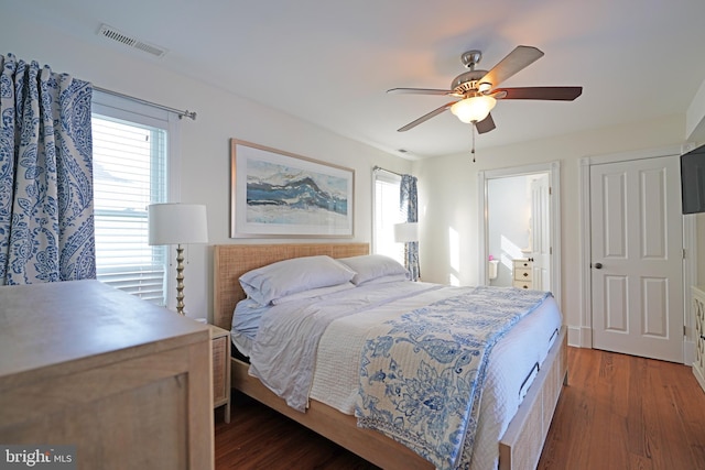 bedroom with dark hardwood / wood-style flooring, multiple windows, and ceiling fan