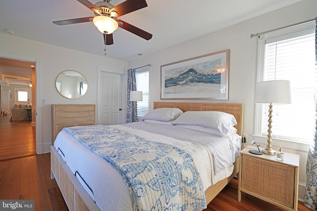 bedroom with a closet, dark hardwood / wood-style floors, and ceiling fan