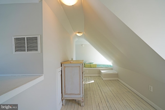 additional living space with vaulted ceiling and light hardwood / wood-style floors