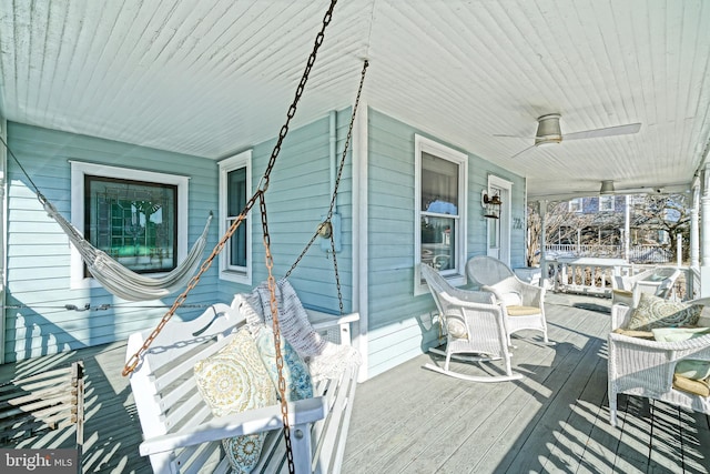 wooden terrace with a porch and ceiling fan