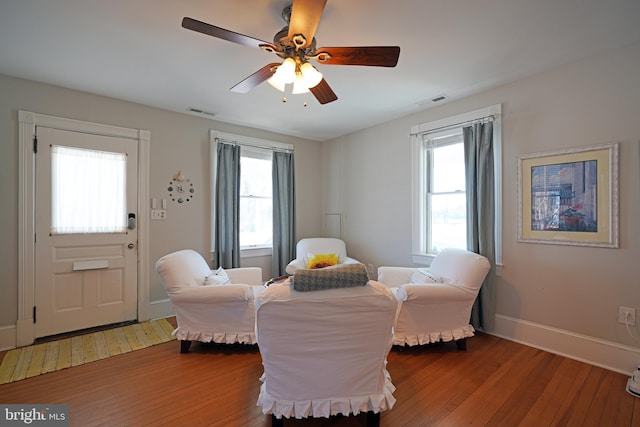 living area with ceiling fan, plenty of natural light, and hardwood / wood-style floors