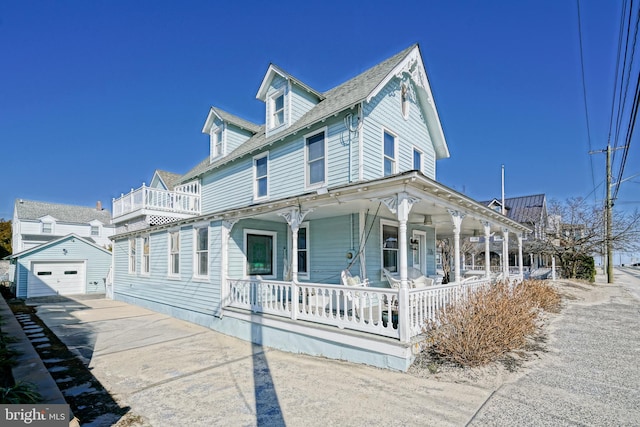 view of front of property with a garage, an outdoor structure, and covered porch