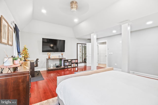 bedroom with ornate columns, ceiling fan, wood-type flooring, and vaulted ceiling