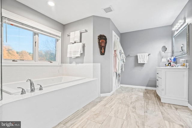 bathroom with a washtub and vanity