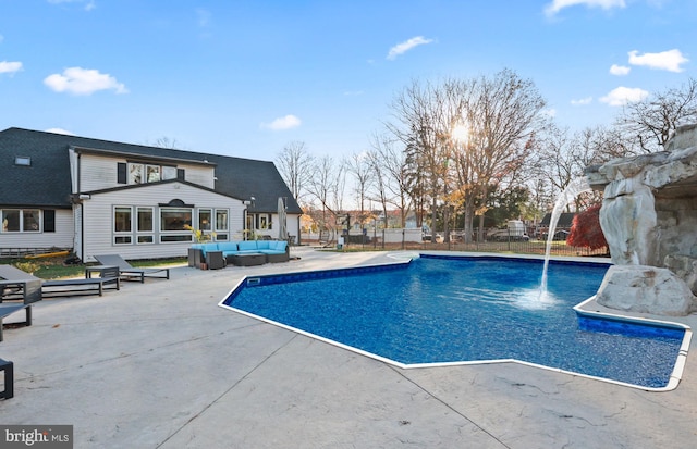 view of pool featuring outdoor lounge area, pool water feature, and a patio