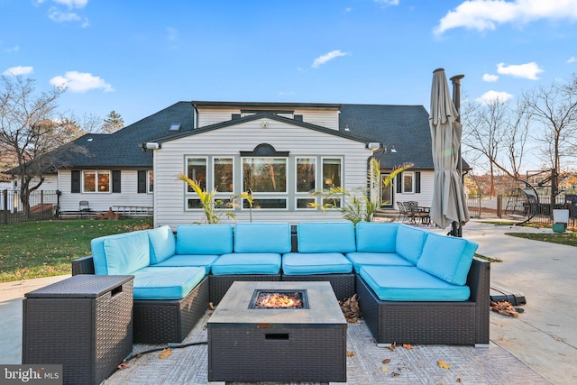 rear view of house featuring a patio and an outdoor living space with a fire pit