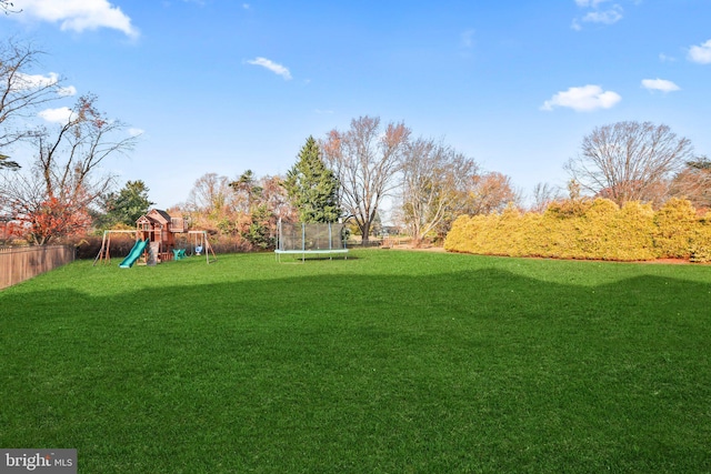 view of yard featuring a trampoline and a playground