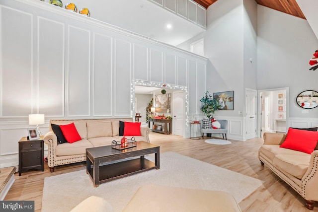 living room with light wood-type flooring and a towering ceiling