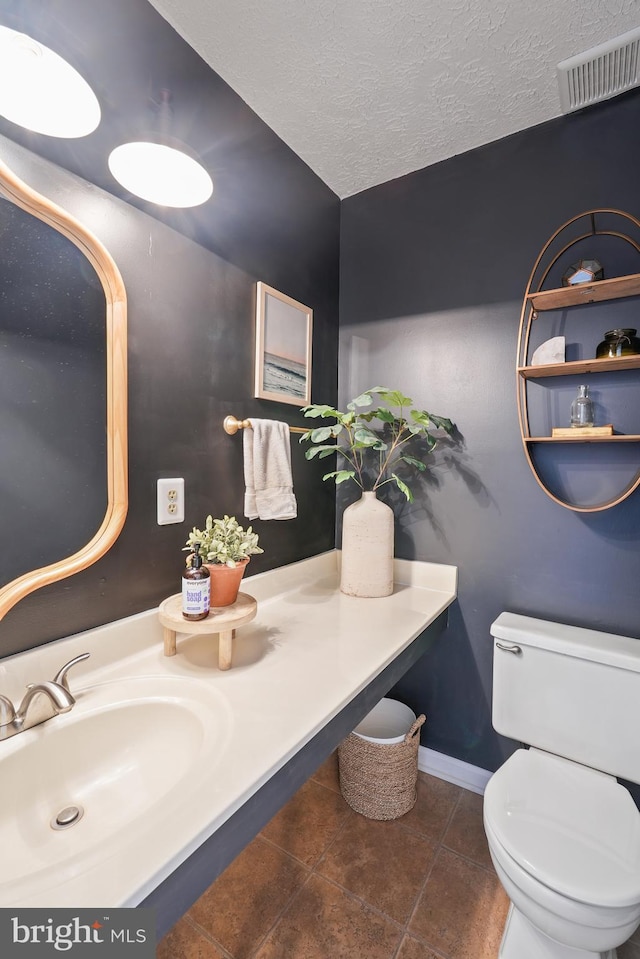 bathroom featuring sink, toilet, and a textured ceiling