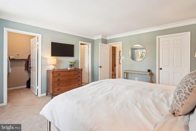 carpeted bedroom with a closet, crown molding, and a spacious closet