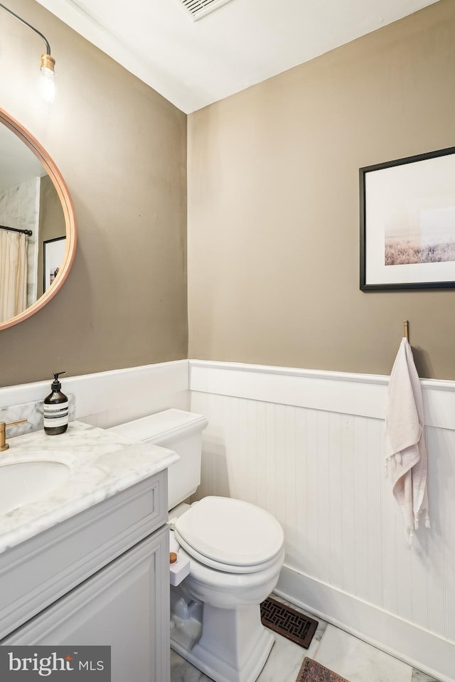 bathroom featuring tile patterned floors, vanity, and toilet