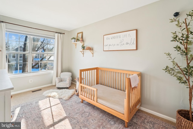 carpeted bedroom featuring a crib