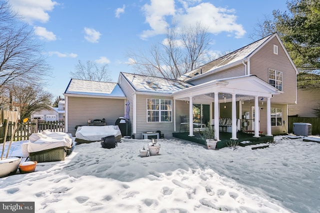 snow covered property featuring central AC and covered porch