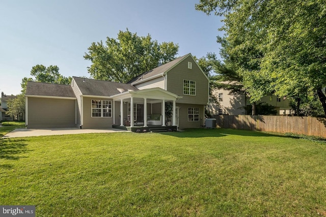 back of property with a lawn, cooling unit, and a patio area