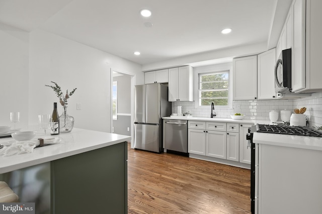 kitchen featuring backsplash, white cabinetry, and stainless steel appliances