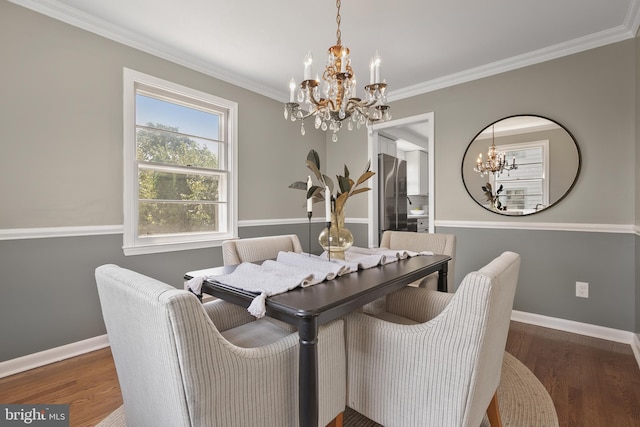 dining space featuring dark hardwood / wood-style flooring, an inviting chandelier, and crown molding